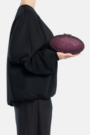 Clutch indare bordeaux, portata a mano dalla modella. TWENTYFOURHAITCH.