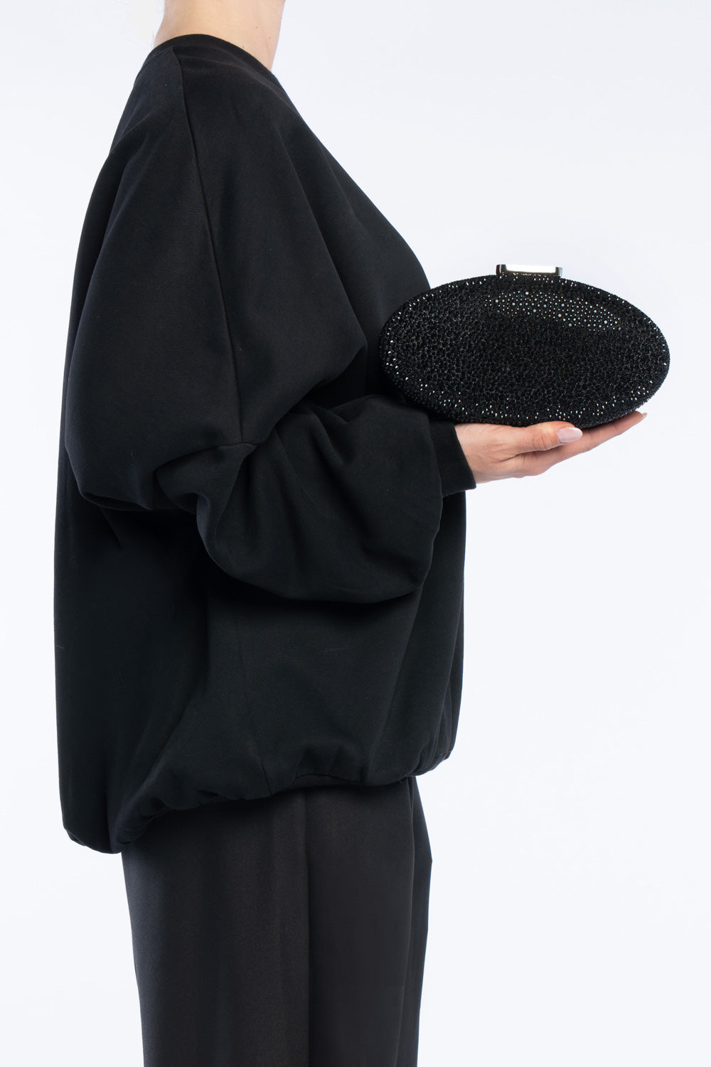 Clutch indare nera, portata a mano dalla modella. TWENTYFOURHAITCH.