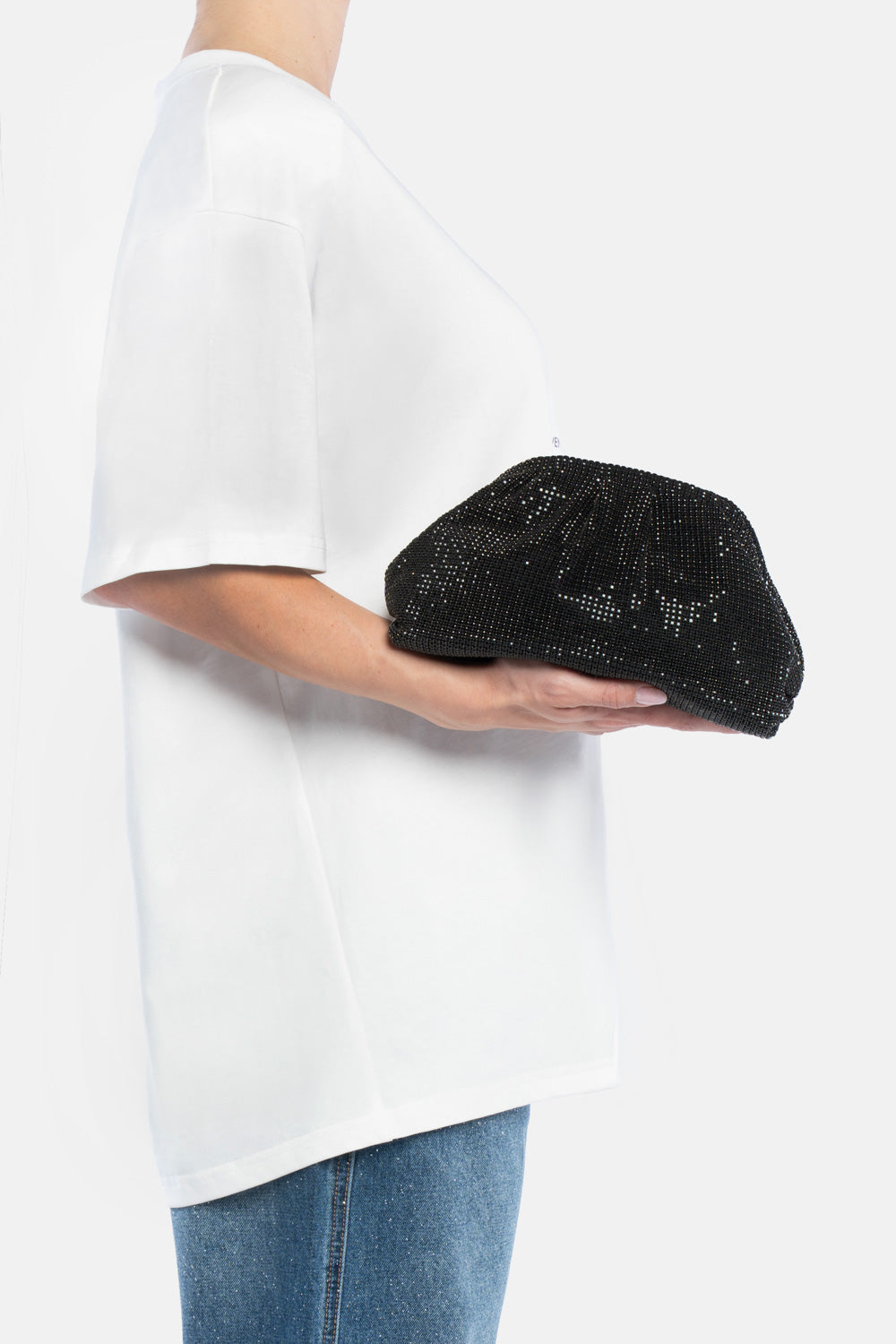 Petra pouch bag nera, portata a mano dalla modella. TWENTYFOURHAITCH.